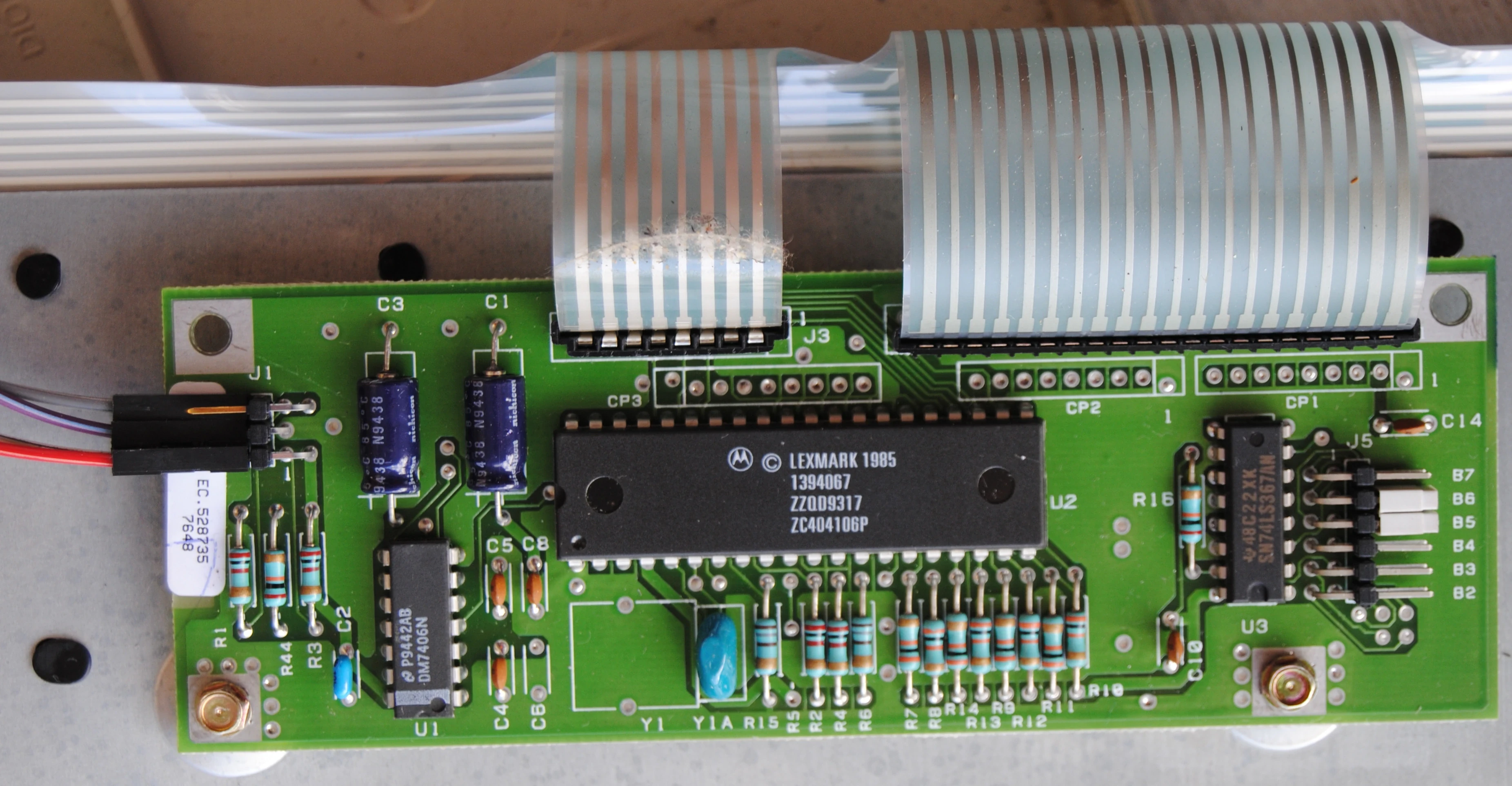 Close-up on the keyboard's PCB. It is of quite good quality. It has a 5-pin 2.54 male header, a big IC marked "Lexmark 1985 1394067 ZZQD9317 ZC404106P" and two DIP-16 ones "DM7406N" and "SN74LS367AN". There are 6 removable jumper positions labelled from B2 to B7. Only B5 and B6 are set.